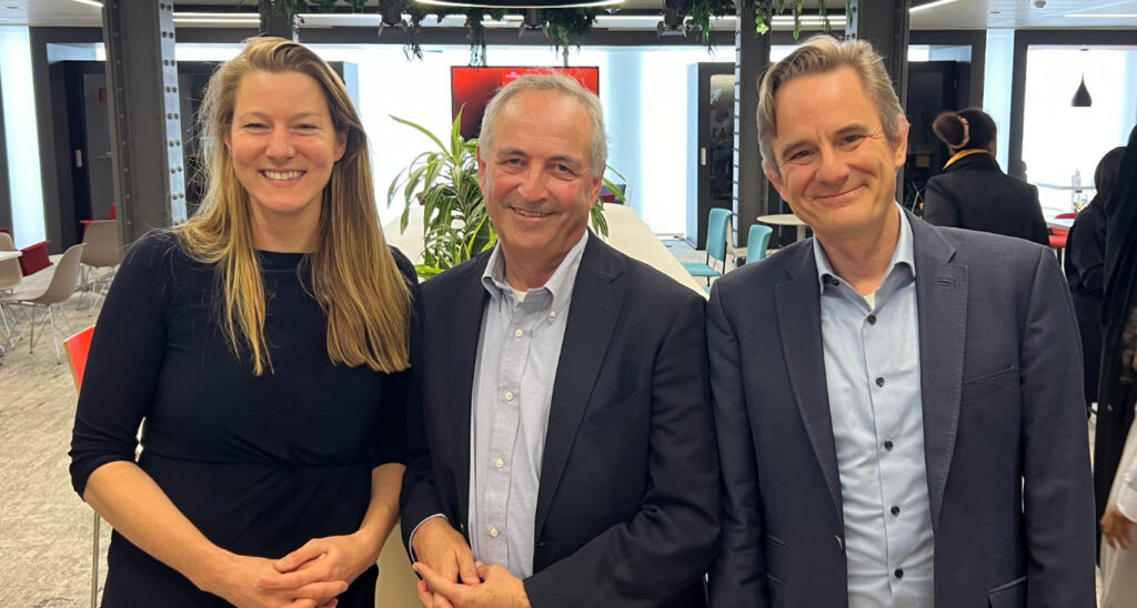CEO, Flora stands alongside the former Chair, Daniel Franklin, and new Chair of Trustees Robert Guest.